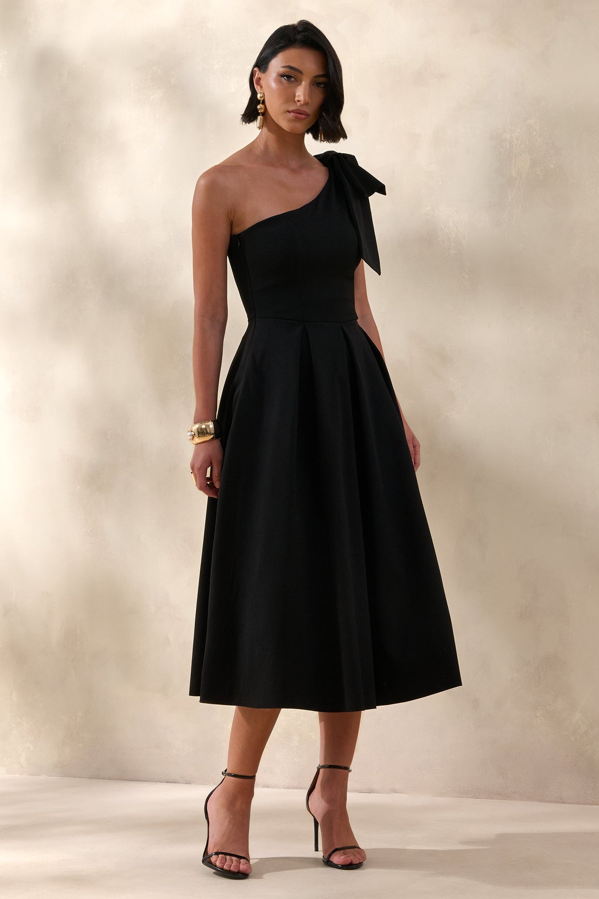Meria | Robe mi-longue noire à encolure asymétrique avec manche ornée d’un nœud